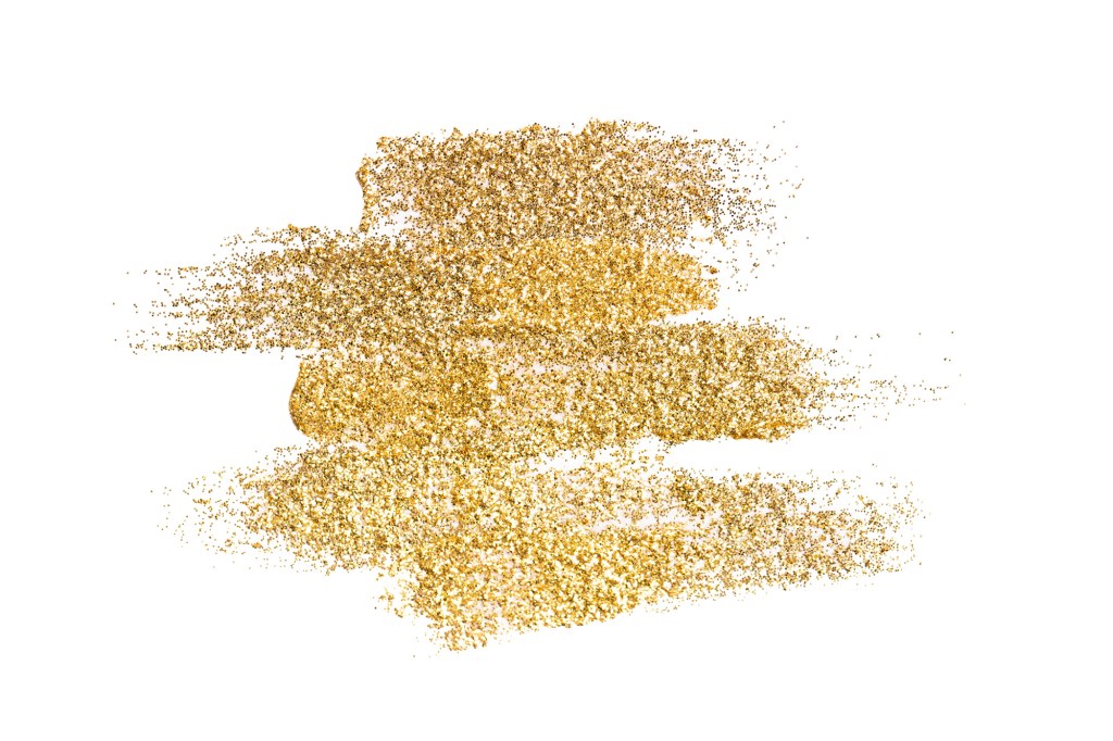 Many golden brushstrokes of decorative cosmetics isolated on a white background.