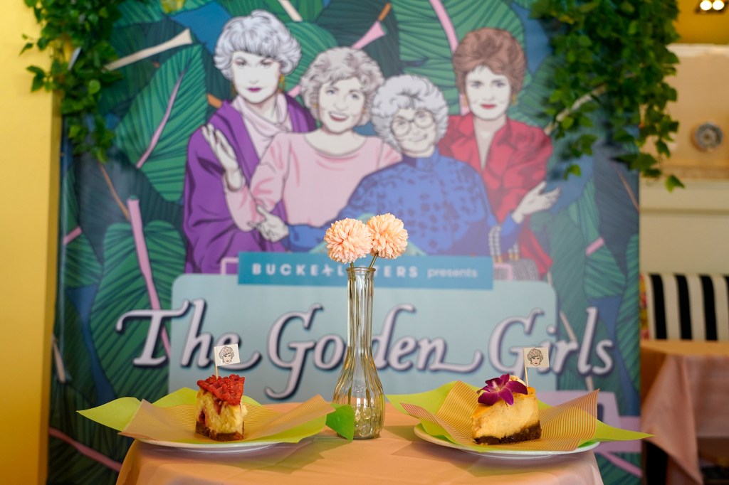 Cheesecake dessert items are pictured in front of a portrait of "The Golden Girls" cast at the Golden Girls Kitchen pop-up restaurant on July 25, 2022, in Beverly Hills, California.