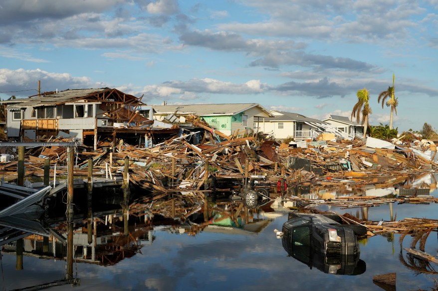 Cars and debris from washed away homes line a canal in Fort Myers Beach after Hurricane Ian.