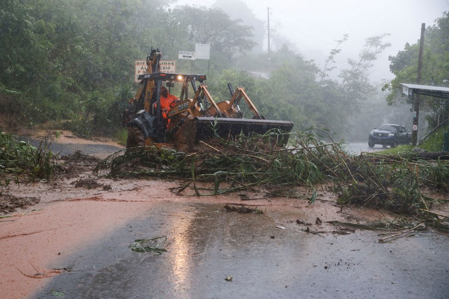 A tractor cleans a landslide caused by Hurricane Julia in Comasagua, El Salvador, on Oct. 10, 2022.