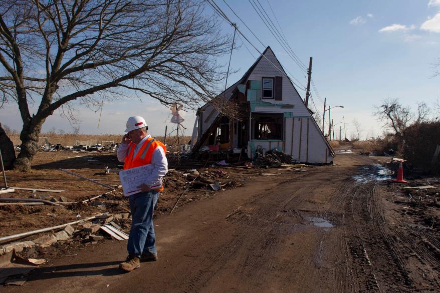 A member of the Army Corps of Engineers walks along Kissam Avenue in the Oakwood Beach area of Staten Island on Nov. 28, 2012.