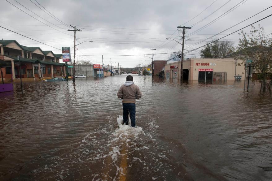 A man walks into the flood waters on Midland Avenue to look for his brother.