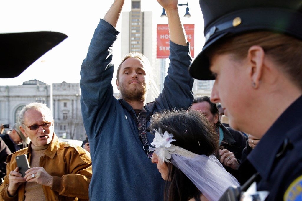 David DePape, center, records Gypsy Taub being led away by police after her nude wedding in 2013.