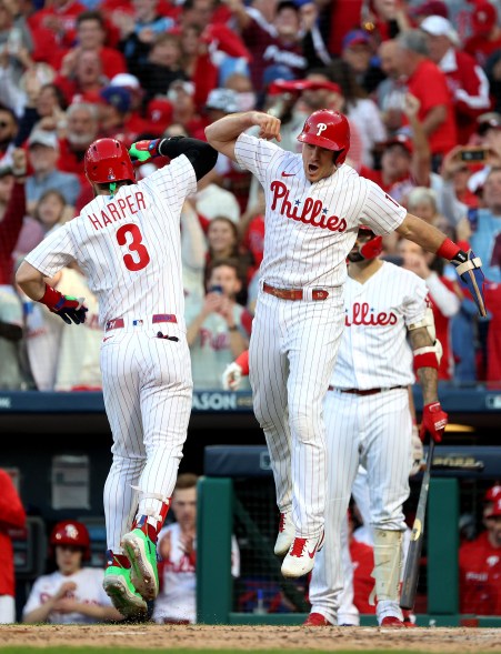 The Philadelphia Phillies' Bryce Harper celebrates with J.T. Realmuto after hitting a two-run home run in NLDS Game 3 on Oct. 14, 2022 in Philadelphia.