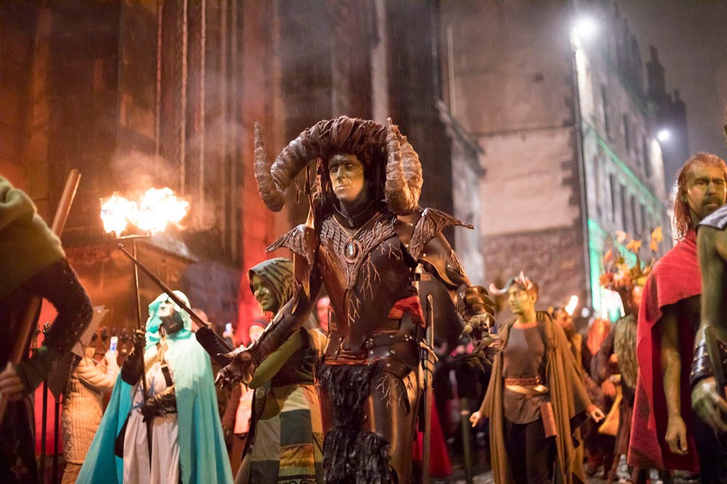 Edinburgh, UK - October 31, 2016: Members of the Beltane Fire Society perform along the Royal Mile in the city centre on a rainy night. The demonic Winter King, along with the Winter King and Cailleach, lead the parade through the streets. Samhuinn, or Halloween, is the Celtic New Year and celebrated with a procession and performance through the city streets.