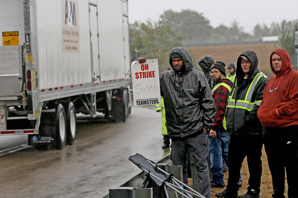 Teamsters who work for Sysco strike outside the facility as nonunion drivers drive in on October 4, 2022 in Plympton, Massachusetts.