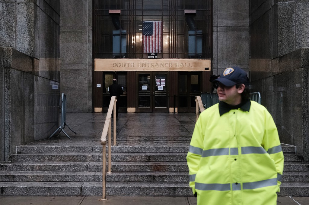 A law-enforcement officer stands outside Manhattan Criminal Court.