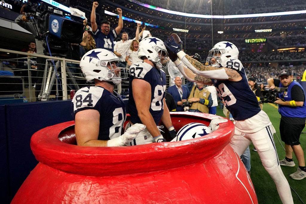 Cowboys player celebrate a fourth quarter by jumping into a Salvation Army pot. 