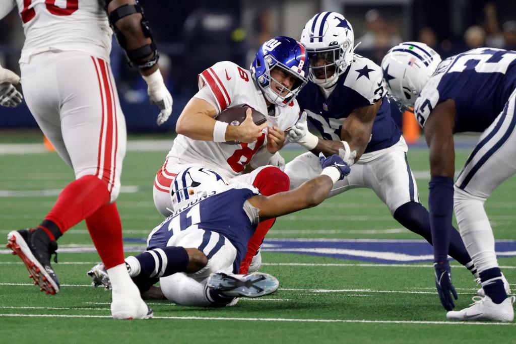 Daniel Jones is tackled by Micah Parsons (No. 11) and Damone Clark during the second half of the Giants' 28-20 loss to the Cowboys.