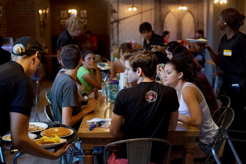 Young people dining sitting around a table at Denny's.