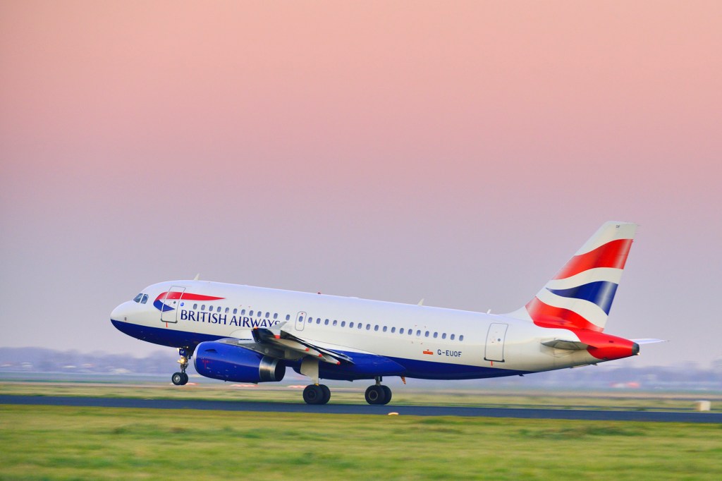 Schiphol, The Netherlands - November 14, 2012: British Airways Airbus A319 taking off from Schiphol airport in a sunset at the end of the day.