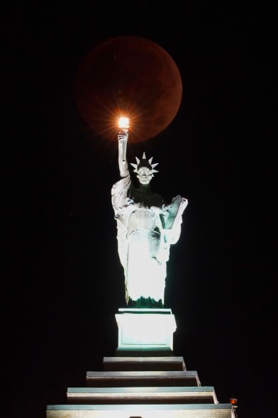 Lady Liberty's beacon shines brightly as the "Beaver Blood Moon," caused by a total lunar eclipse, passes behind the Liberty Building on Nov. 8, 2022 in Buffalo, New York.