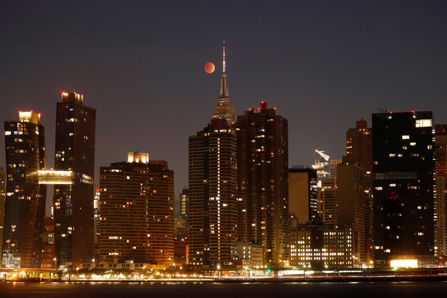 The blood-red full Beaver Moon passes behind the Empire State Building during a total lunar eclipse on Nov. 8, 2022 in New York.