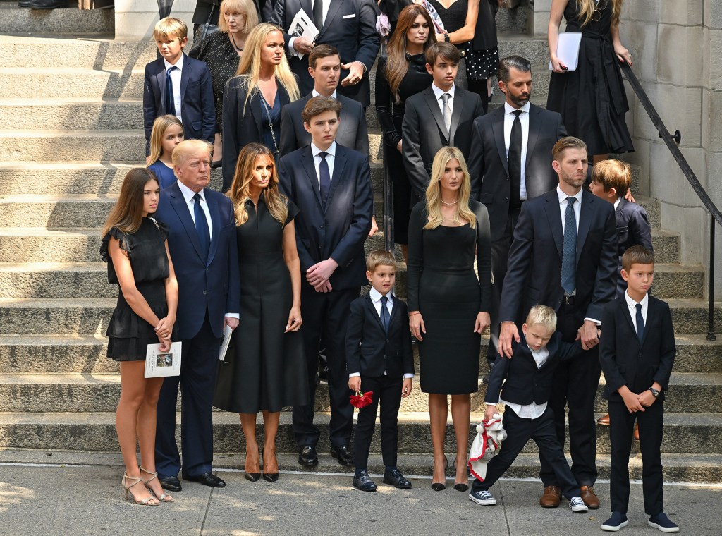 Trump and family members stand on a staircase.