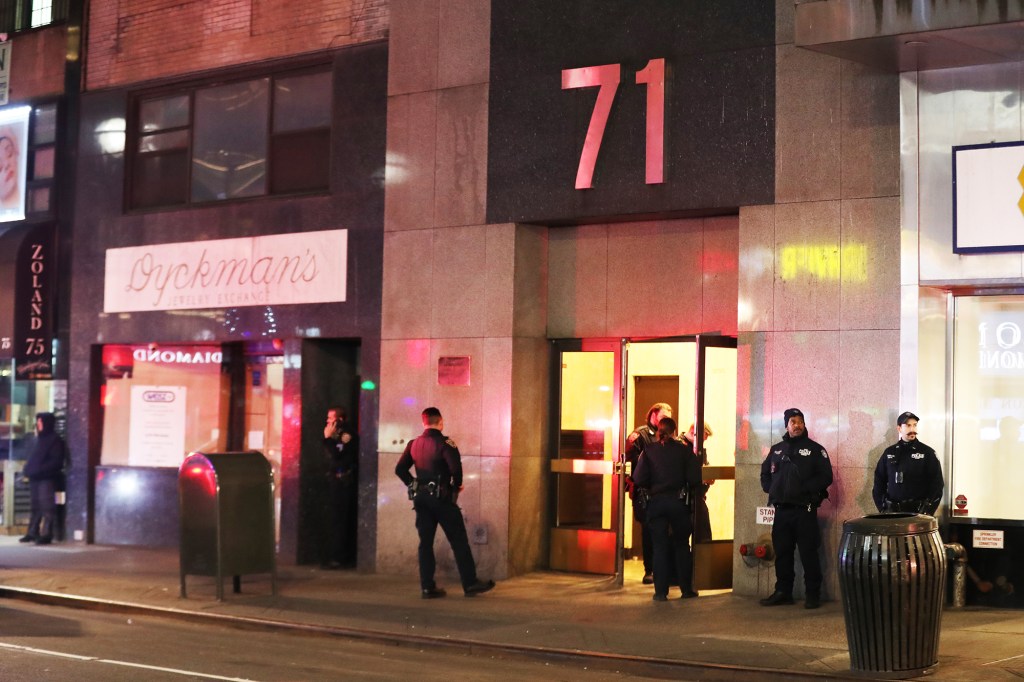 Police stand outside 71 West 47th Street, the scene of the Monday night gunpoint robbery.