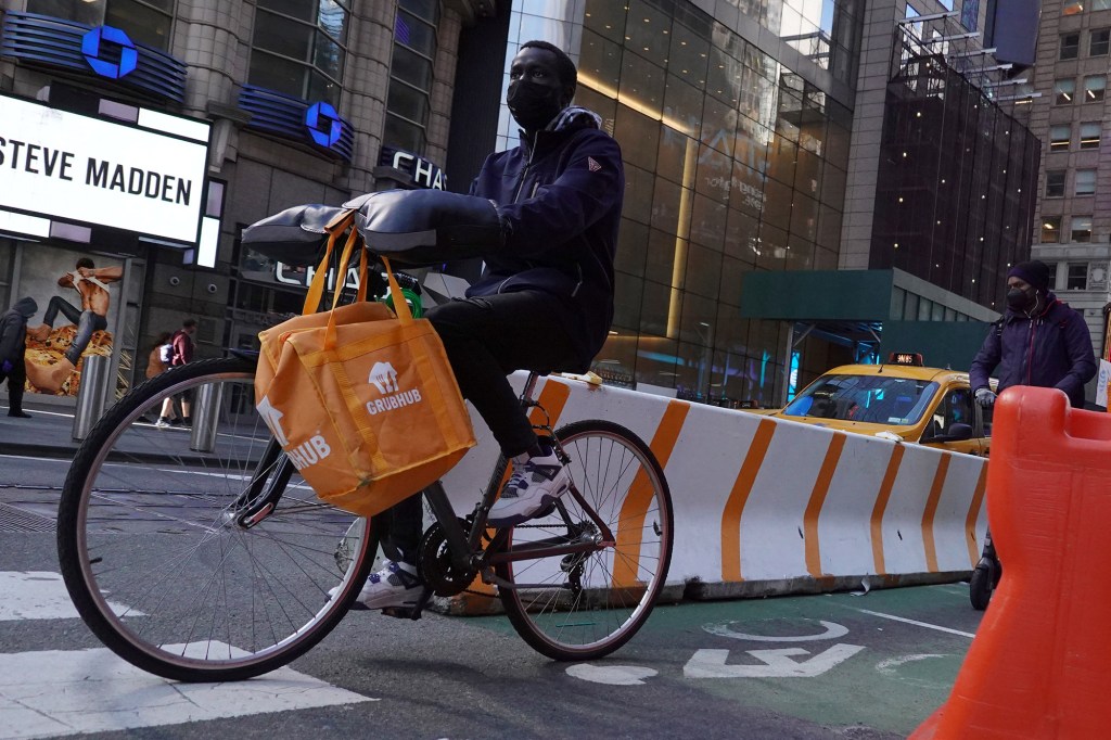 A Grubhub delivery person rides in Manhattan.