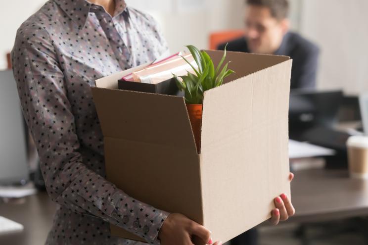 Female employee holding cardboard box.