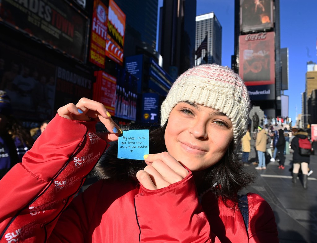 woman holds up confetti with wish