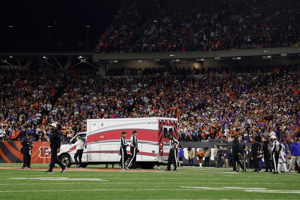 Fans look on as the ambulance leaves carrying Bills safety Damar Hamlin after he suffered cardiac arrest on the field against the Bengals at Paycor Stadium on Jan. 2, 2023 in Cincinnati, Ohio. 