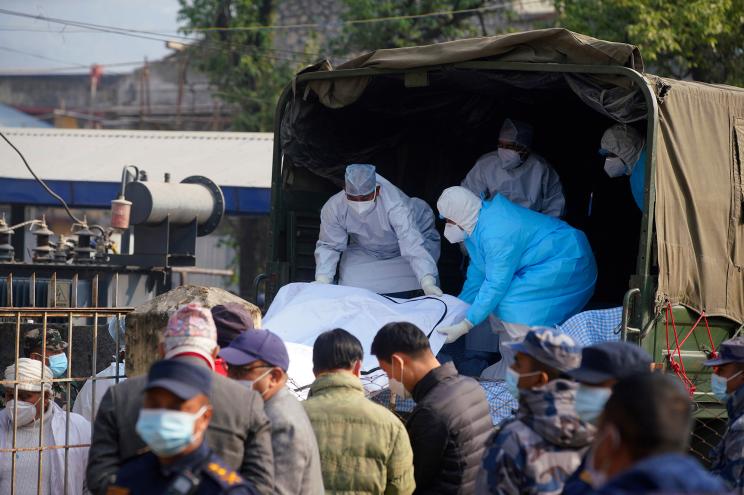 Medical personnel load the body of a victim.