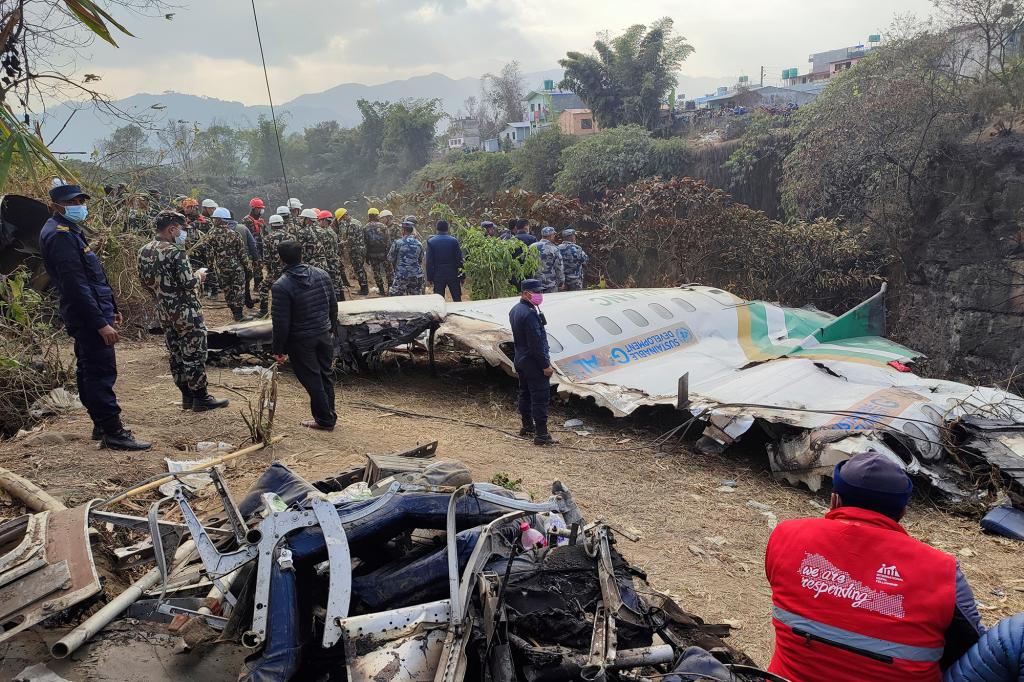 Rescuers stand by wreckage of a passenger plane that crashed in Pokhara, Nepal, Monday, Jan 16, 2023.