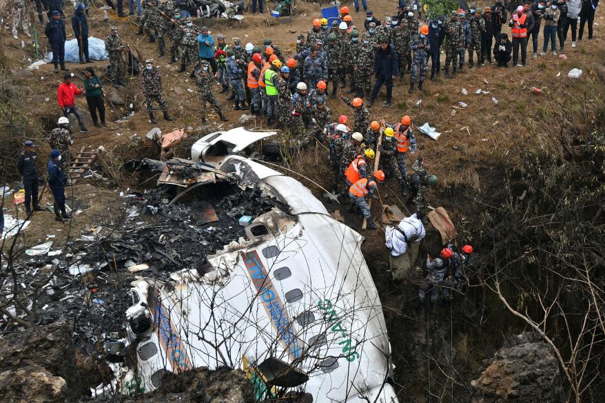 Rescuers pull the body of a victim who died in a Yeti Airlines plane crash in Pokhara on January 16, 2023.