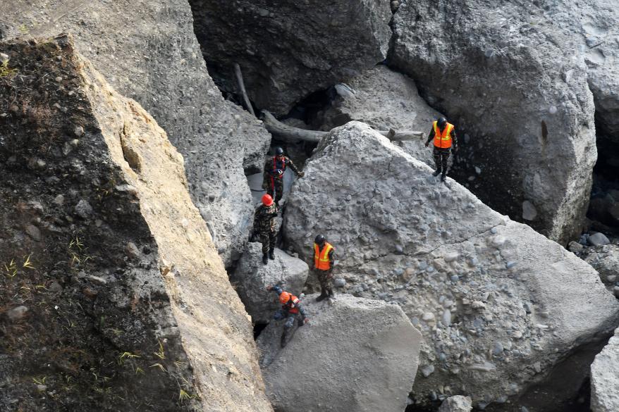 Rescue personnel search for victims at the site of the Yeti Airlines plane crash.