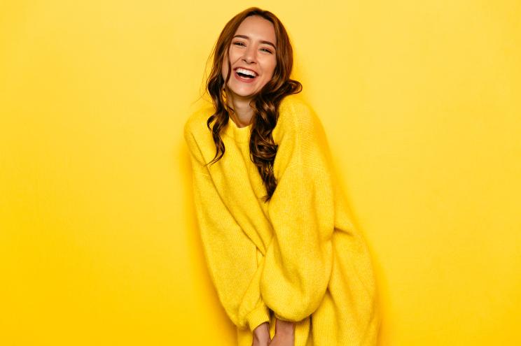 Girl in yellow sweater on yellow background