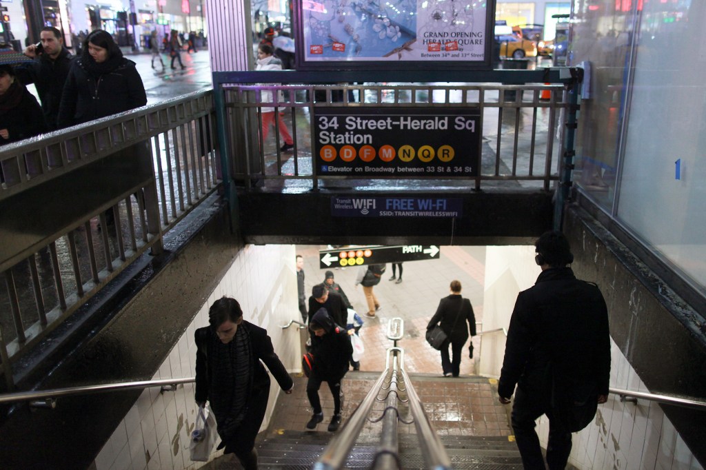 Commuters walk up and down a staircase at the 34th Street-Herald Square station.