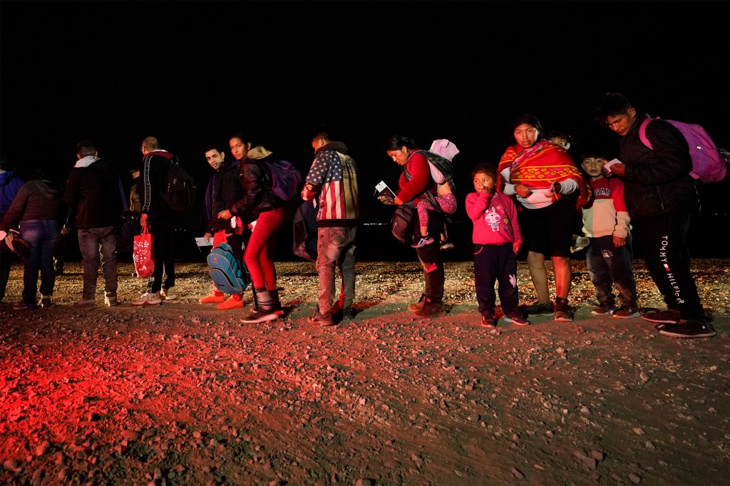 Migrants wait to be process after crossing the border near Yuma, Arizona on January 6, 2023.