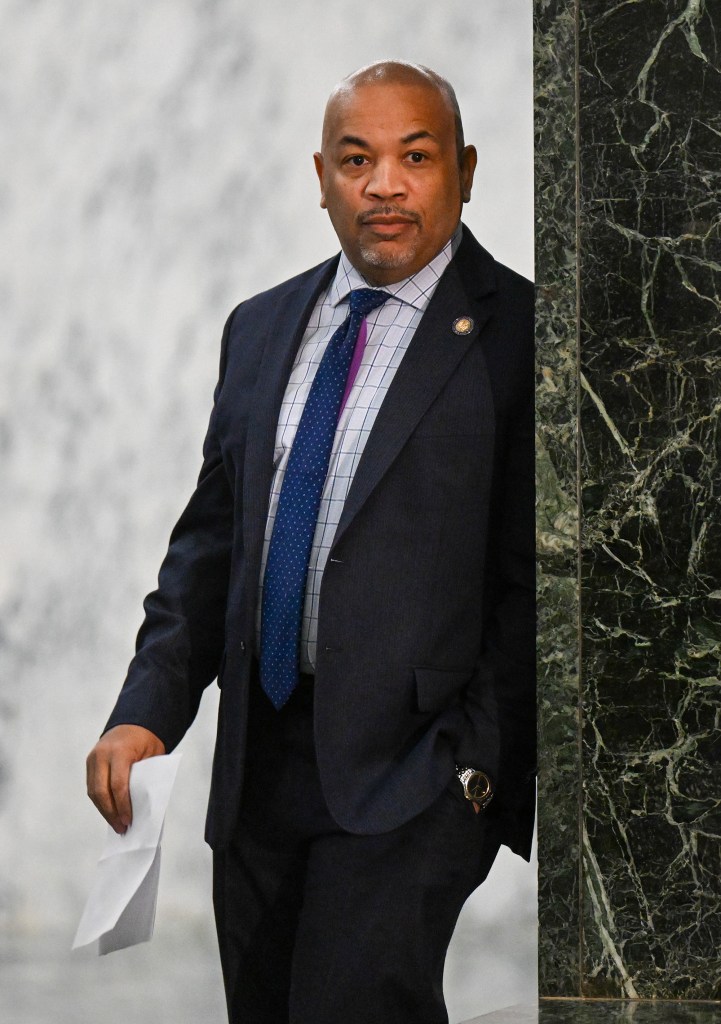 Carl Heastie in a suit leaning on a marble wall in the Legislative Office Building in Albany.