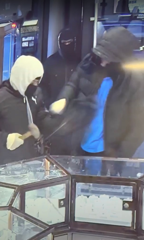 Masked men smash cases and grab jewelry.