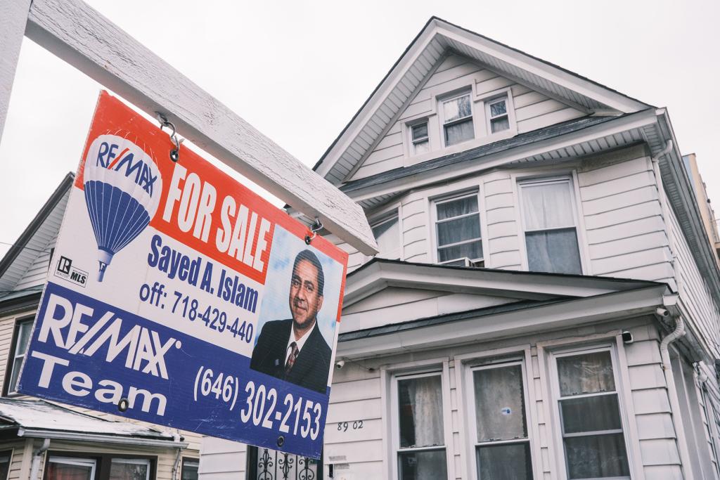 A single-family home in Jamaica, Queens, with the listing sign for the listing agent.