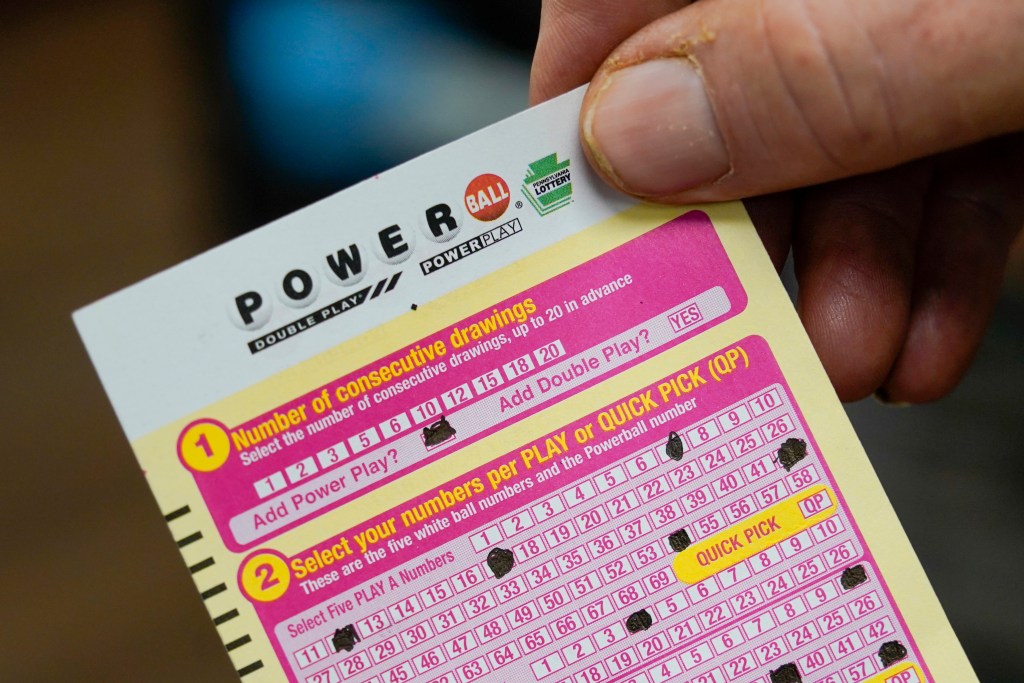 FILE - Steve Morton shows his scan card for his personal selection numbers for a ticket for a Monday Powerball 