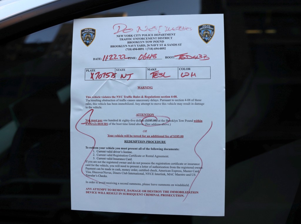 A New York City traffic ticket is sticked to a window of a car