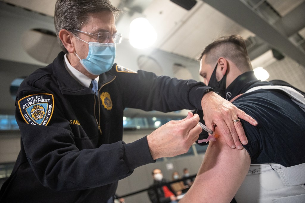 A member of the New York Police Department (NYPD) receives a dose of the Moderna Covid-19 vaccine at Queens Police Academy in the Queens borough of New York, U.S., January 11, 2021.