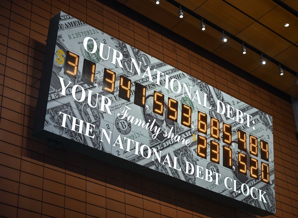 A screen shows the national debt clock after the US hit its debt limit.