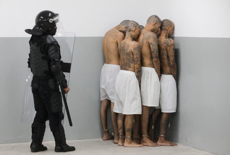 A prison agent guards gang members.