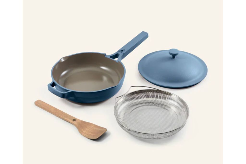 Light blue cooking pan with lid and cooking accessories. 