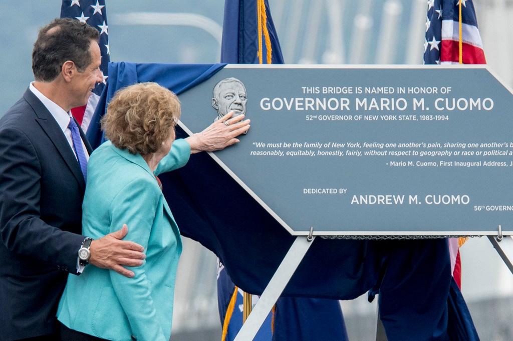 Matilda Cuomo touches a sculpture of her late husband Mario Cuomo with her son, Andrew at her side.