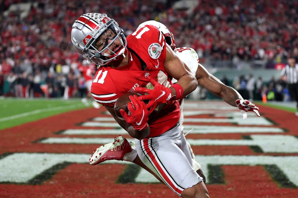 Jaxon Smith-Njigba #11 of the Ohio State Buckeyes catches a touchdown pass as Malone Mataele #15 of the Utah Utes defends during the fourth quarter in the Rose Bowl Game at Rose Bowl Stadium on January 01, 2022 in Pasadena, California.