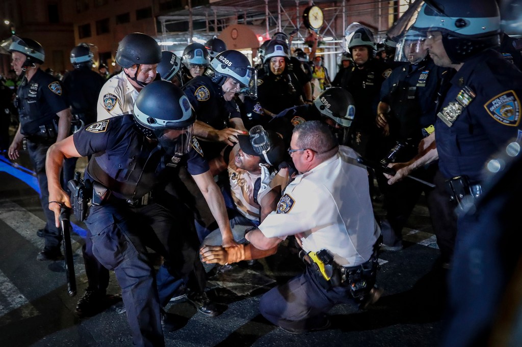 A protester is arrested by NYPD officers on Fifth Avenue during a march on June 4, 2020, following the death of George Floyd.
