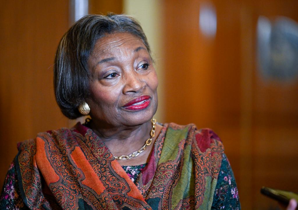 Andrea Stewart-Cousins with a trademark scarf standing and looking to the side with a blurry background