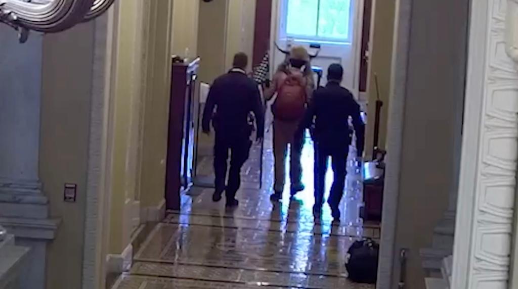 Jacob Chansley is seen with Capitol police during the Jan. 6 riot.