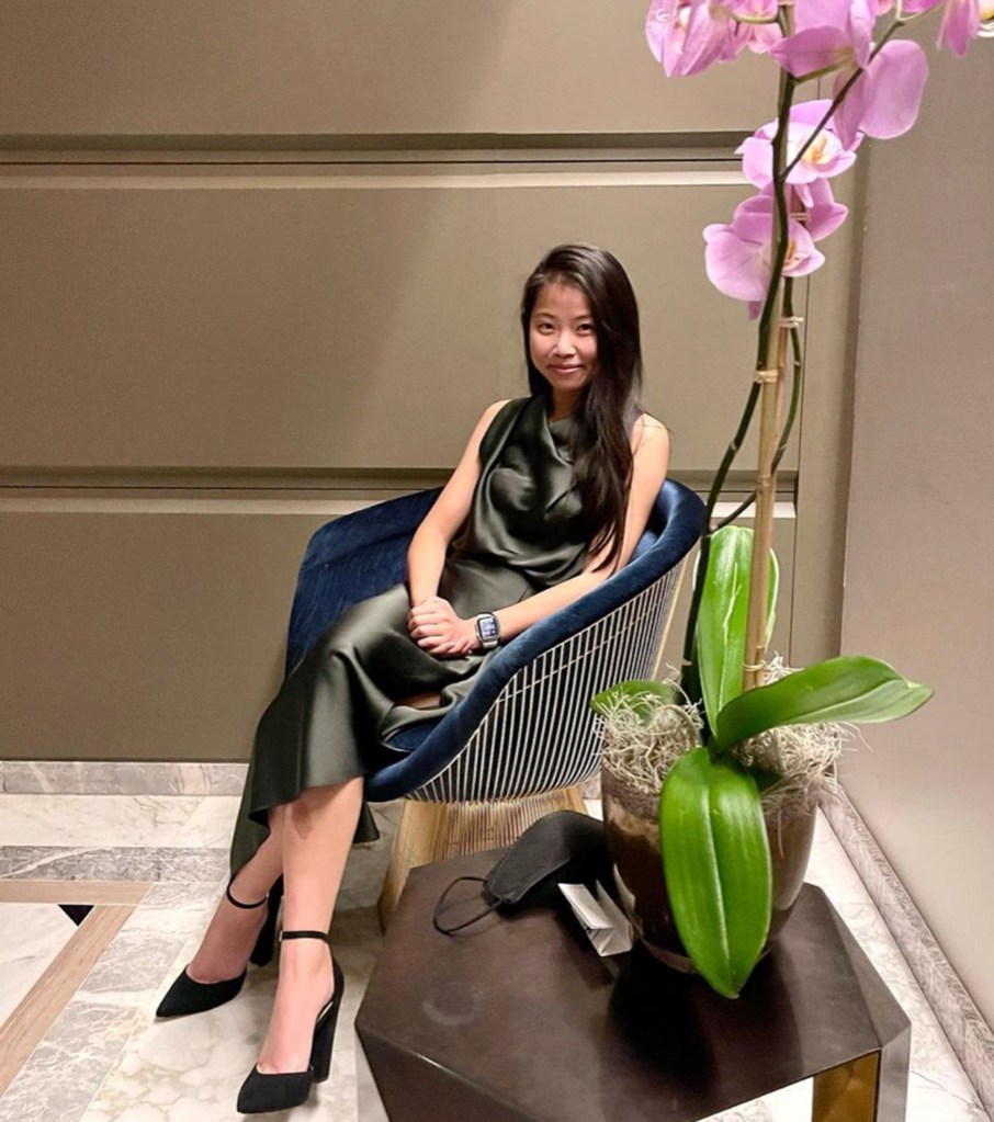 Kimberly Nguyen sitting next to a large orchid