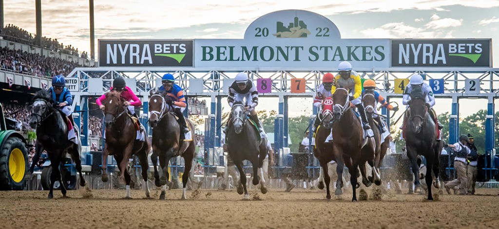 Jockeys riding horses on a track inside Belmont