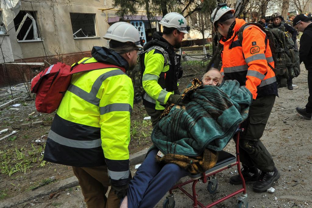 Medics carry a man evacuated from a residential building damaged by a Russian missile strike attack on Ukraine.