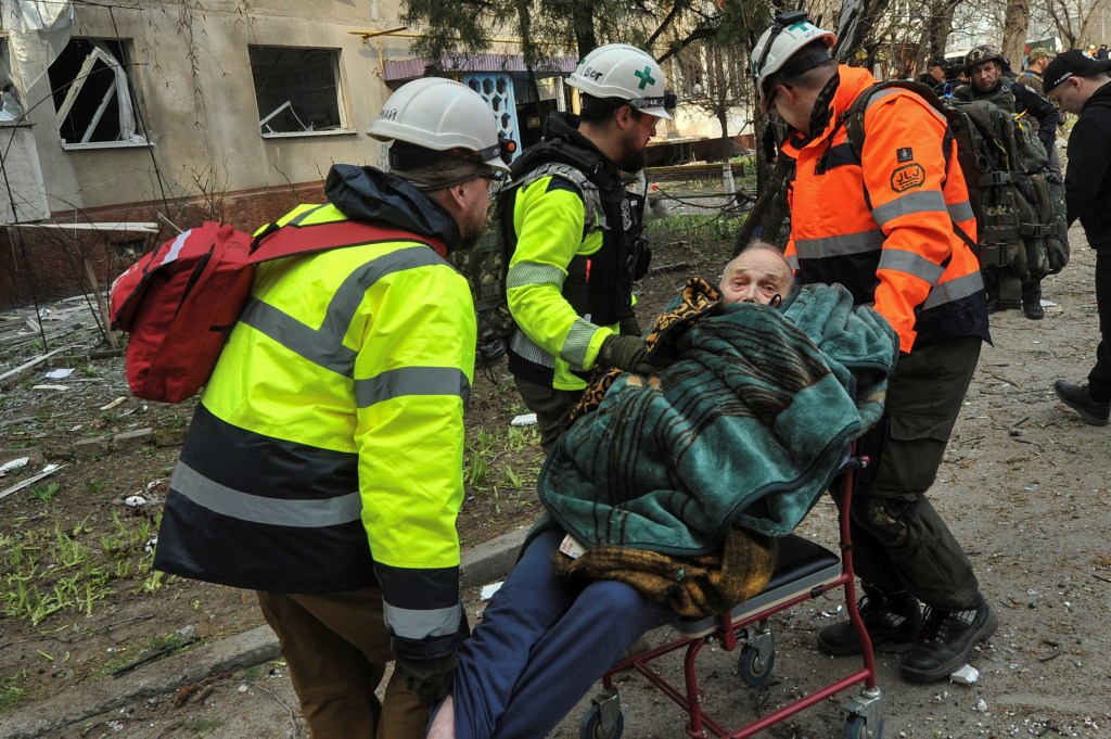  Medics carry a man evacuated from a residential building damaged by a Russian missile strike attack on Ukraine.
