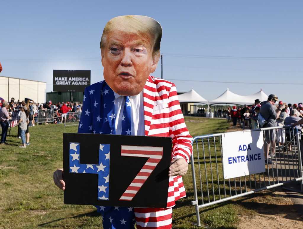 Trump supporter dressed as Donald Trump holding 47 sign