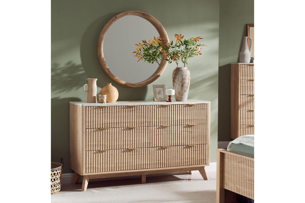 A cane dresser with a mirror and vases on top of it.